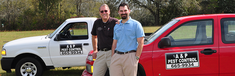 The founders of A&P Pest Control standing proudly with their service trucks